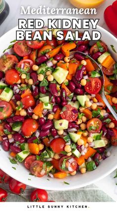 a white bowl filled with red kidney bean salad next to tomatoes and cucumbers