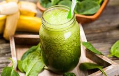 a green smoothie in a mason jar with a straw