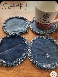 four denim coasters with holes in them sitting on a table next to a coffee mug