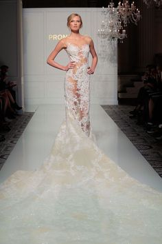 a woman is walking down the runway in a white dress