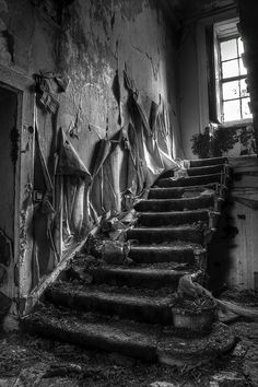 black and white photograph of stairs in an abandoned building