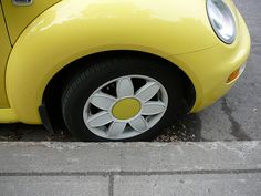 a small yellow car is parked on the street