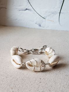 Summer ready bracelet with the prettiest cowries. Alternating wire wrapped cowries using your choice of gold plated or silver plated wire. Bold toggle clasp, and thick jumprings make this bracelet stand out. The additional jumprings also act as and an extender so it fits from 6.5" to 8.5" wrist.  Comes boxed and ready for gifting. Beach Jewelry With Adjustable Chain Bracelet, Silver Metal Beaded Bracelet For Beach, Elegant Metal Bracelets For Beach, Elegant Handmade Bracelets For Vacation, Adjustable Chain Bracelet For Beach, Metal Charm Bracelet For Beach, Vacation Bracelet With Lobster Clasp, Metal Oyster Bracelet For Beach, White Cowrie Shell Bracelet