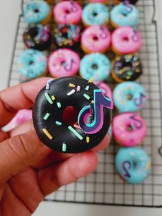 a person holding up a doughnut with the letter j on it and sprinkles