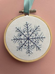 a cross stitch snowflake hanging on a wall