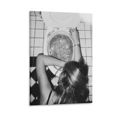 black and white photograph of a woman sitting on the floor in front of a toilet