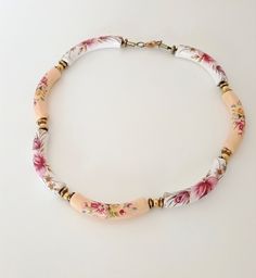 6.00 cm long white and beige ceramic beads, painted with romantic flowers, consist a girlish, romantic short necklace, made in the '80s. Each bead is a small piece of art and together they create a very beautiful, easy to wear, necklace. Total length 44.00 cm, stands high at the neckline. Simple and elegant, the ultimate spring and summer necklace for your light dresses. The necklace is not new, so there can be time signs on it. In perfect condition. Bohemian White Hand Painted Necklace, Elegant White Hand Painted Necklaces, Light Dresses, Boho Statement Necklace, Beige Ceramic, Flowers Decoration, Light Dress, Romantic Flowers, Summer Necklace