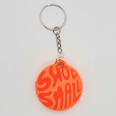 an orange and red keychain with the word shop small on it's side