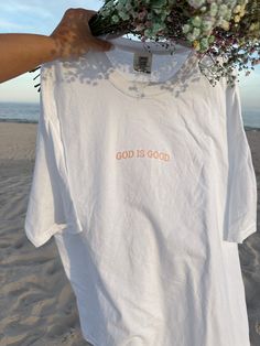 Introducing our Women's Boyfriend Tee, a perfect blend of dainty and trendy fashion with a faith-based touch. This relaxed-fit tee is designed for both comfort and style, crafted from soft, high-quality fabric. The front features a delicate, dainty embroidery of the phrase "God is Good," adding a subtle yet meaningful accent. Its versatile design makes it easy to pair with jeans, shorts, or skirts for a chic, casual look. Embrace your faith and style with this cute and trendy tee, a must-have ad Inspirational Relaxed Fit T-shirt For Spring, Inspirational White T-shirt For Everyday, Inspirational Short Sleeve T-shirt For Summer, Inspirational Graphic Print T-shirt For Summer, Pink T-shirt With Embroidered Text For Summer, Inspirational Letter Print T-shirt For Spring, Pink Embroidered T-shirt For Summer, Inspirational Pink Cotton T-shirt, Inspirational Crew Neck Summer Top