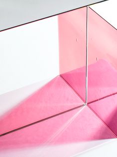 a pink object is reflected in a mirrored surface that looks like it has been folded over