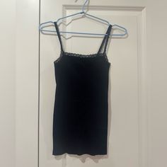 Brandy Melville Vintage Black Lace Trim Camisole All Orders Ship In 1-3 Business Days! Brandy Melville Black Lace Trim Camisole One Size (Fits Most Similarly To A Small) Color: Black Brand: Brandy Melville Style: Lace Trim Camisole Condition: Nwot (Never Worn, Perfect Condition)No Flaws, No Holes, No Rips, No Stains, No Pilling, No Visible Signs Of Wear // Clean Condition Measurements (See Photos): - 22.5" Length - 17" Front Center Length - 11.5" Bust - 10.25" Across Bottom Hem All Measurements Black Tops With Adjustable Straps For Loungewear, Black Spaghetti Strap Loungewear Top, Black Lace Trim Spaghetti Strap Camisole, Fitted Black Camisole With Scoop Neck, Stretch Scoop Neck Camisole For Night Out, Fitted Camisole Tank Top For Loungewear, Black Sleeveless Camisole With Lace Trim, Fitted Black Tank Top With Lace Trim, Black Camisole With Built-in Bra For Loungewear