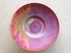 a pink and yellow bowl sitting on top of a table