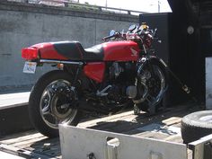 a red and black motorcycle parked on the back of a truck