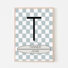 a framed poster with the letter t in black and white checkerboard, on a wall