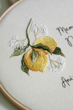 a close up of a embroidery on a piece of cloth with flowers and words written in cursive writing