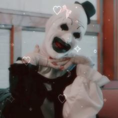 a person wearing a panda mask and holding a cell phone to their face with hearts drawn on it