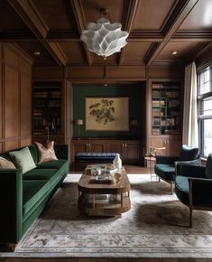 a living room filled with green couches and chairs next to a large book shelf