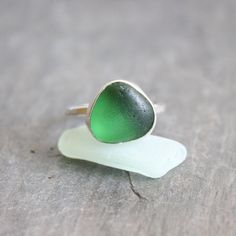 Sterling Silver Emerald Green Sea Glass Ring Do you need a gift for someone who is hard to buy for?  Or for someone who has everything?  Sea glass jewelry is always a great gift to give!  Here are the details about this ring:   * This is a small emerald green piece of sea glass from England is set in fine and sterling silver and soldered to a sturdy twisted silver band. It is simple, classic and perfect...and goes with everything! All of my sea glass is found and never altered in any way. Size 7 Handmade Sea Glass Ring Jewelry, Green Stackable Jewelry For The Beach, Beach-ready Green Stackable Jewelry, Round Sea Glass Jewelry Gift, Handmade Green Rings With Recycled Glass, Handmade Glass Rings For Gift, Personalized Green Jewelry For Beach, Personalized Green Jewelry For The Beach, Sea Glass Ring