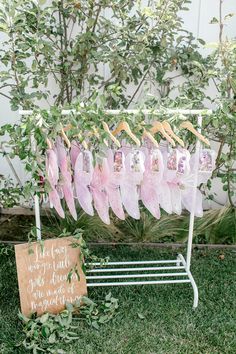 pink feathers hang on a clothes line with a sign