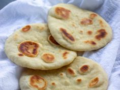 three pita breads sitting on top of a white towel next to each other