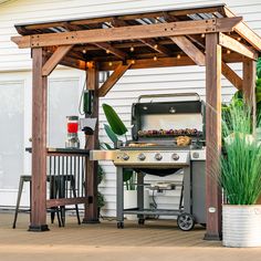 an outdoor bbq grill with lights on it and a potted plant next to it