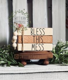 a wooden sign that says welcome to our home on top of a table with greenery