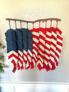 two red, white and blue blankets hanging on a wall next to a potted plant