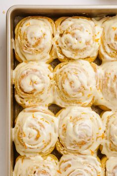 a pan filled with cinnamon rolls covered in icing