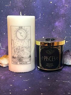 two candles sitting next to each other on top of a purple surface with stars in the background