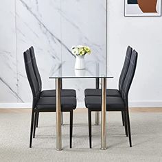 a glass dining table with black chairs in front of a marble wall and white rug