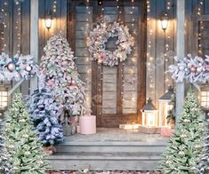 christmas decorations on the front steps of a house with lights and wreaths around them