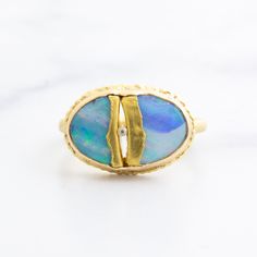 This mesmerizing Boulder Opal ring is full of life. Flashes of green, blue, and red dance across its surface as the light brings it to life. Two strips of delicately placed 22K gold ribbon hold this mesmerizing stone in place with a .004ct diamond nestled between. It sits atop an 18K gold open back setting, allowing the magical stone to touch your skin as it is worn, adding an extra layer of intimacy to the innovative design. Size 7.25 - please purchase a resize if you need a different size Red Dance, Boulder Opal Ring, Opal Diamond Ring, Magical Stones, Gold Ribbon, Gold Ribbons, Opal Ring, Boulder Opal, Innovative Design