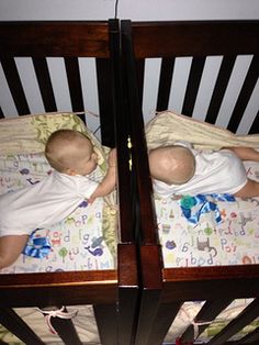 two babies sleeping in cribs next to each other