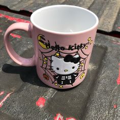 a hello kitty coffee mug sitting on the ground