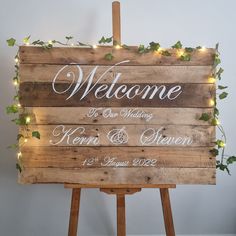 a wooden sign with lights on it that says welcome to our wedding