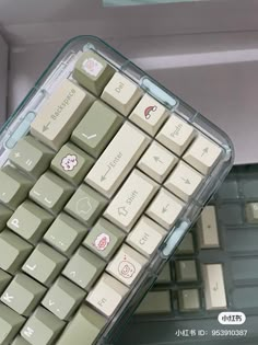 a computer keyboard sitting inside of a plastic case with stickers on it's side