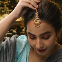 a woman wearing a gold necklace and head piece