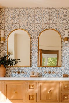 a bathroom with two sinks and mirrors on the wall