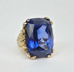 Celebrating 34 years in business and 23 years on eBay!! Our Store | Our Feedback | Contact Us                                     14k Yellow Gold 30ctw Lab Grown Blue Sapphire Leaf Solitaire Cocktail Ring 4'' Brought to you by Pawn and Jewelry is this pre owned ring. This listing is for the ring ONLY. It weighs 14.3grams or 9.2dwt, the top of the ring is about 21mm wide, there is about a 30ct lab grown blue sapphire (about 20.16mm x 14.95mm x 9.79mm), and is about a size 4” which can be resized for an additional charge. This ring is a slightly low 14k yelow gold. Type: Ring Metal: Yellow Gold Metal Purity: 14k Weight (grams): 14.3grams Weight (dwt): 9.2dwt Main Stone: Blue Sapphire Main Stone Creation: Lab-Created Total Carat Weight (TCW): 30ctw Total Carat Weight: 10.00 & Over Ring Size: Heirloom Sapphire Ring For Formal Occasions, Heirloom Style Sapphire Ring For Formal Occasions, Formal Fine Jewelry Sapphire Ring With Vvs Clarity, Fine Sapphire Rings For Formal Occasions, Sapphire Ring For Formal Occasions, Formal Sapphire Jewelry With Diamond Cut, Formal Sapphire Gemstone Ring, Formal Fine Jewelry With Sapphire, Formal Yellow Gold Sapphire Ring