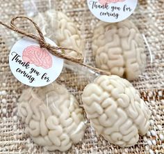 three small white brain shaped treats wrapped in cellophane and tied with twine