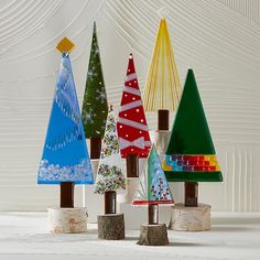 colorful christmas trees are lined up on wooden posts