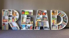 the word read spelled out with books in front of a wall filled with toys and books