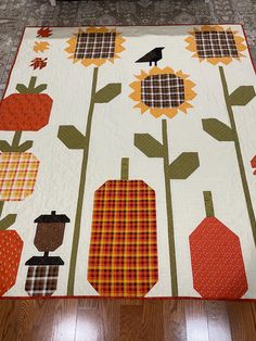 a quilted table runner with sunflowers, pumpkins and birds on it