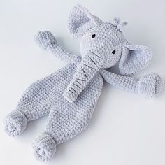 a crocheted stuffed elephant laying on its side