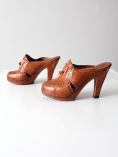 "This is a pair of 1970s vintage clogs by Brasil. The brown leather high heel mules feature cut out design and leather tie details. CONDITION In good condition with wear consistent with age and use. Leather is splitting slighting from wood at heel on one shoe. Marked Size: 6 US MEASUREMENTS Insole Length: 9 .. 22.9 cm Width: 2.5\" .. 6.4 cm Wall to Toe Length: 8.5\" .. 21.6 cm Heel: 4.25\" .. 10.8 cm 82159" 70s Clogs, Vintage Oxford Shoes, 1970s Shoes, Clogs Outfits, Vintage Clogs, Oxford Shoes Brown, Hippie Boots, Goth Shoes, Clogs And Mules