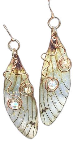 the earrings are made out of glass and gold plated wire, with an intricate butterfly wing