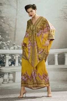 Mustard yellow kaftan tunic with floral print and shell tuck at the neckline. - Aza Fashions Flowy Tunic Kaftan For Eid, Yellow Maxi Length Kaftan For Spring, Gold Kaftan For Summer Vacation, Bohemian Summer Kaftan With Dabka Detailing, Bohemian Dabka Kaftan For Summer, Printed Kaftan For Eid, Gold Bohemian Kaftan For The Beach, Bohemian Yellow Dress With Kimono Sleeves, Floral Print Kaftan For Beach And Eid