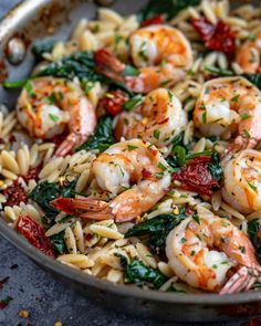 pasta with shrimp, spinach and sun dried tomatoes in a skillet ready to be eaten