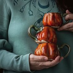 a woman holding three ceramic pumpkins in her hands, with the caption cathrine - fehu