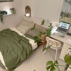 a bedroom with a bed, desk and laptop computer